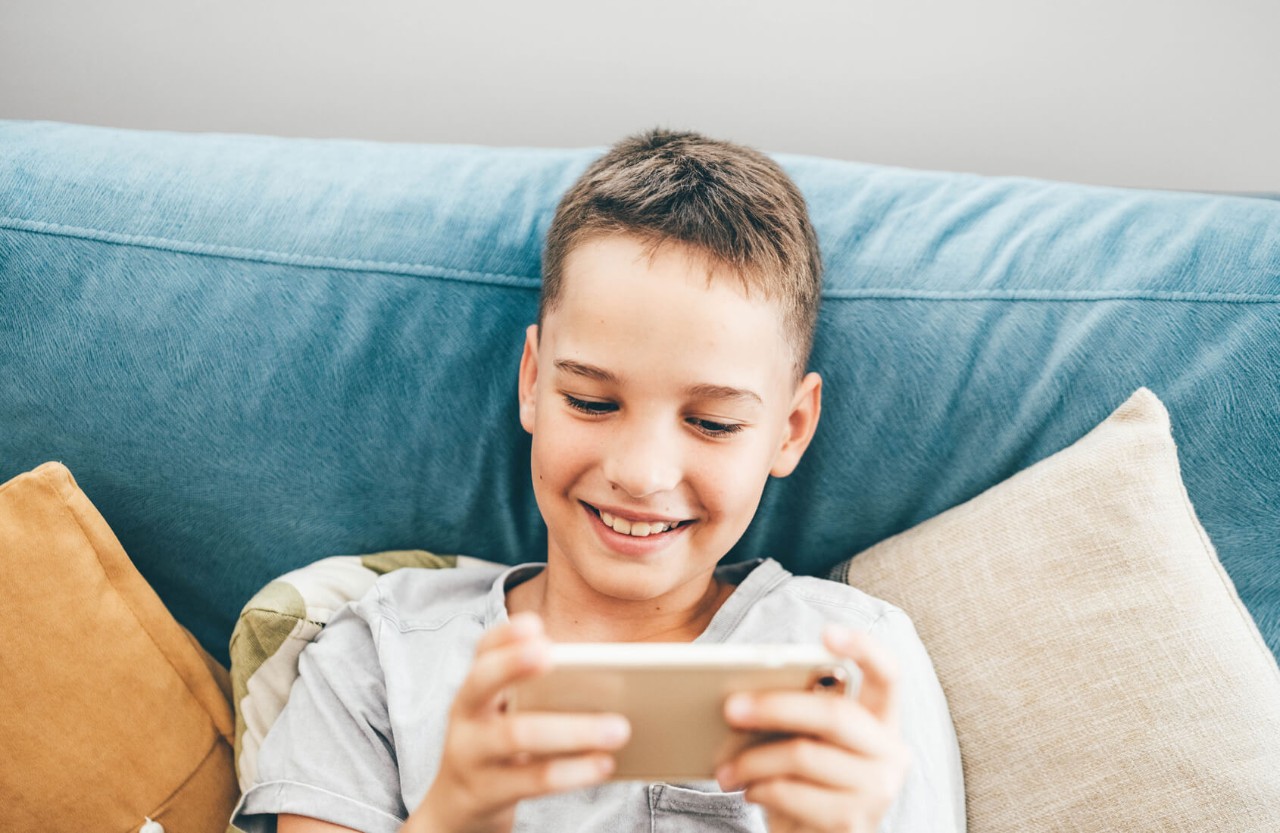 A boy on a sofa on his phone