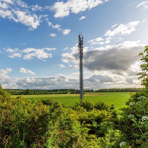 Sunset view British Mobile Operator Mast over field.