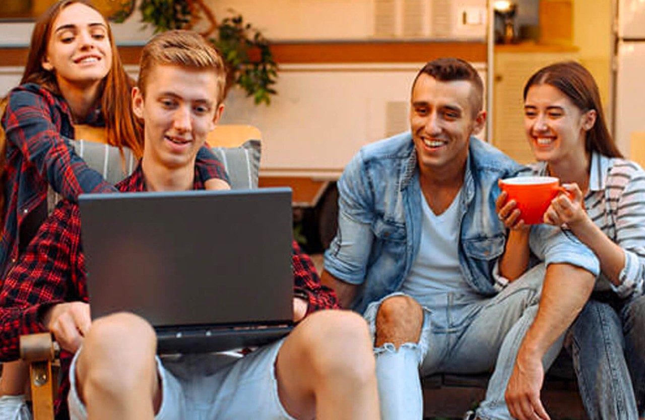 Young people crowded around a laptop