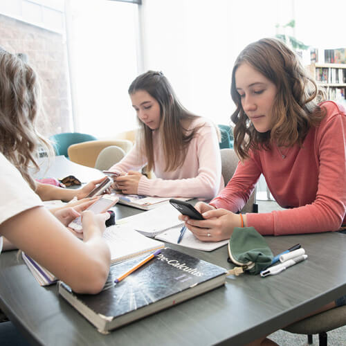 School children using phones while studying